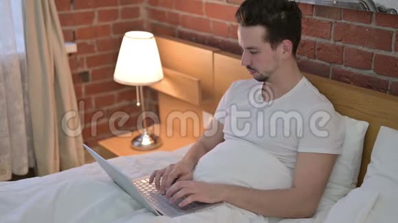 年轻人在床上工作时咳嗽视频的预览图