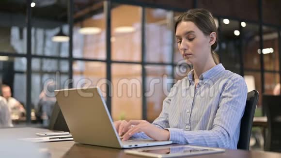生病咳嗽的年轻女子在电脑上工作视频的预览图