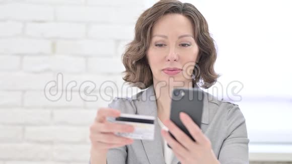 使用智能手机信用卡的老妇人视频的预览图