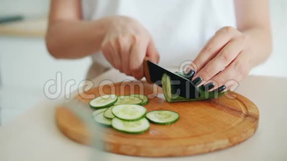 厨房用刀切黄瓜的女性手部动作视频的预览图