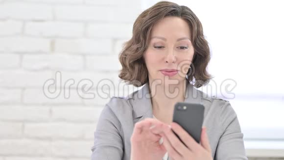 老妇人在智能手机上得到惊喜视频的预览图