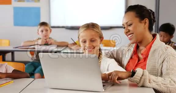 教师和女生在教室里使用笔记本电脑视频的预览图
