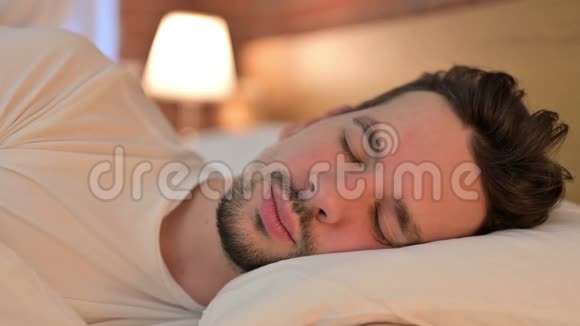 生病的年轻人在床上咳嗽的肖像视频的预览图