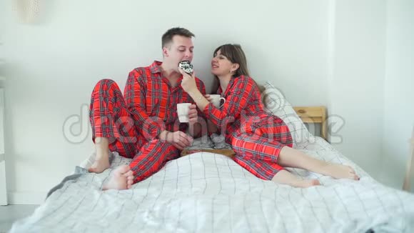 快乐的一对夫妇早上在床上吃甜甜圈视频的预览图