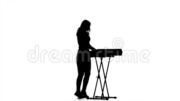 弹钢琴的女性剪影白色背景慢动作视频的预览图