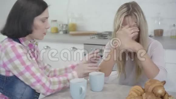 深色白种人女人的肖像冷静下来她的朋友坐着闭着脸用手女人友谊视频的预览图