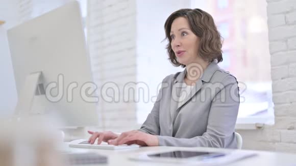 有创意的老妇人在电脑上庆祝成功视频的预览图