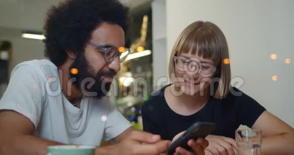 两个兴奋的朋友在现代咖啡馆坐在一起玩得很开心好看的男人和女人说话视频的预览图