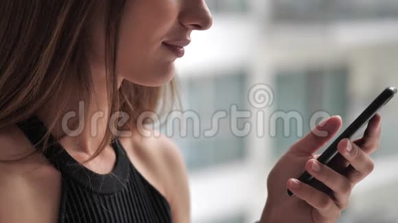 女性点击窗口背景4k智能手机视频的预览图
