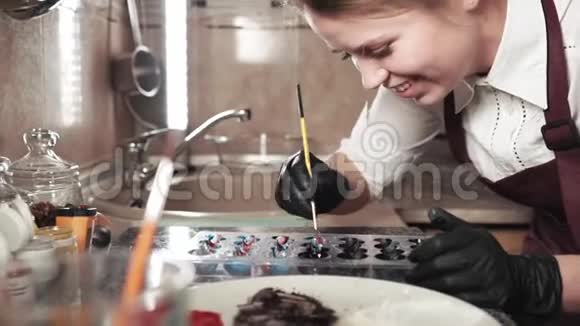 微笑的女性巧克力师制作糖果油漆模具工艺视频的预览图