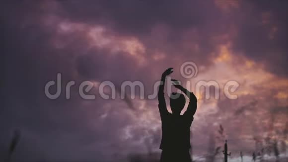 一位留着短发的年轻女子在夏天黄昏的田野里独自跳舞视频的预览图