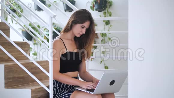 有魅力的漂亮女士集中精力在笔记本上她坐在商务大楼4k的楼梯上视频的预览图