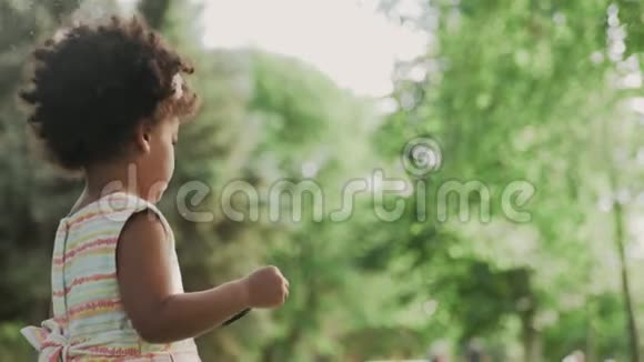 小非洲裔美国女孩在公园里玩放大镜视频的预览图