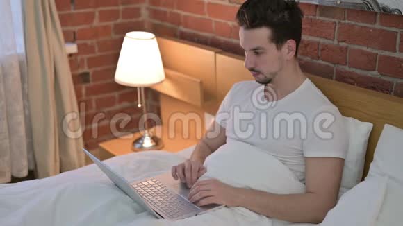 在床上用电脑聊天的年轻人视频的预览图
