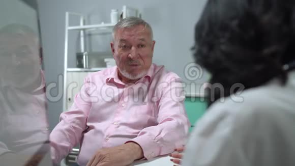 老人坐在医院的柜子里和医生说话视频的预览图