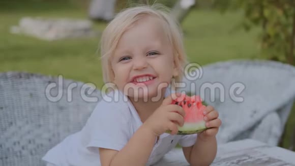 小男孩一边看着摄像机一边吃西瓜一边可爱的微笑视频的预览图