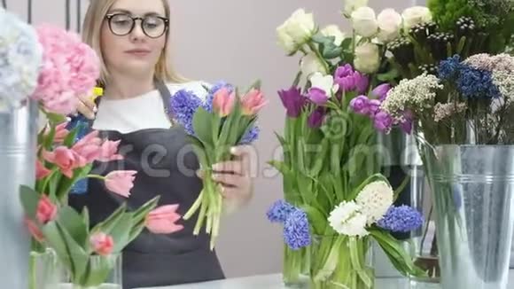 年轻的女人做了一束新鲜的郁金香洒满鲜花的女孩视频的预览图
