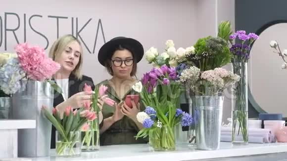 两个年轻的女孩花店里数花商店里出售植物视频的预览图
