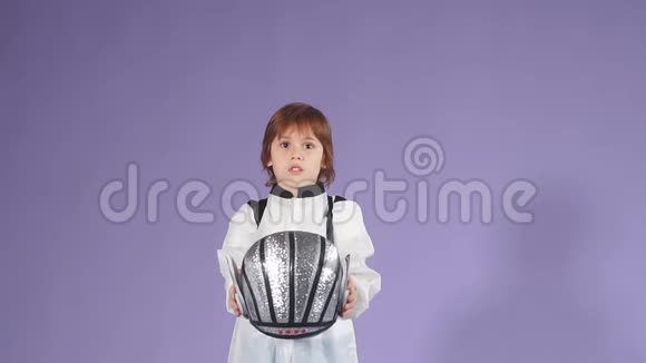 美丽的孩子穿着白色的太空人西装在空中抛掷头盔视频的预览图