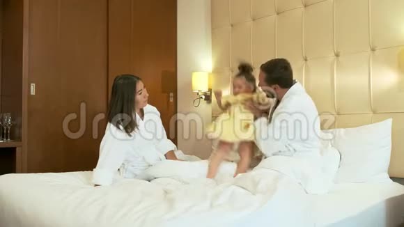 幸福的家庭在床上玩耍视频的预览图