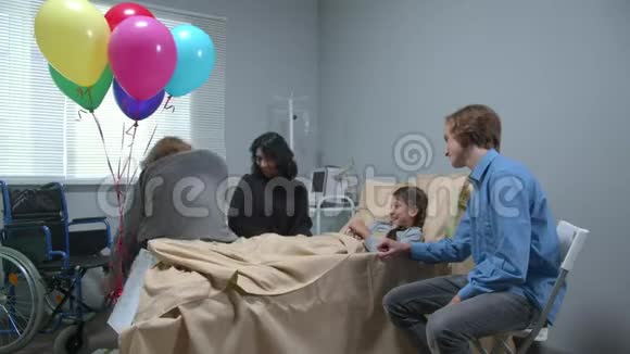 侧视亲戚送礼物给躺在医院床上的女孩视频的预览图
