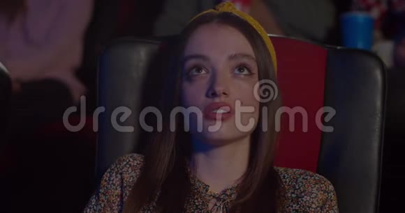在电影院看惊悚片的女孩的特写镜头千禧一代女性面对恐怖时刻的反应视频的预览图