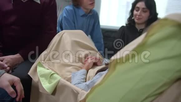 人们坐着和躺在医院床上的女孩说话视频的预览图