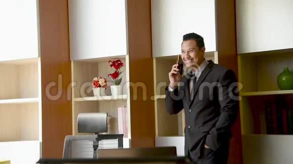 公司办公室漂亮的执行老板亚洲英俊的商人在办公室里用智能手机说话商务人士赠送巴士视频的预览图