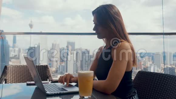 自信的商务女性正在商务中心露台上的笔记本电脑上工作时髦漂亮的女人做一个视频的预览图
