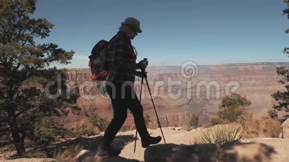 大峡谷公园岩石上背包徒步旅行的女人的侧景视频的预览图