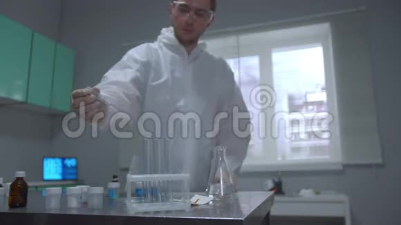 在实验室里把液体倒入试管中的防护服科学家视频的预览图