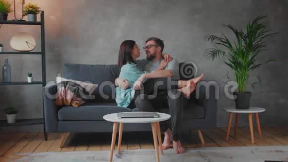 年轻的一家人一起在沙发上玩耍家庭幸福家庭舒适视频的预览图