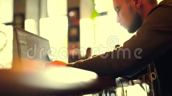 一个自由职业者坐在咖啡馆工作笔记本电脑视频的预览图