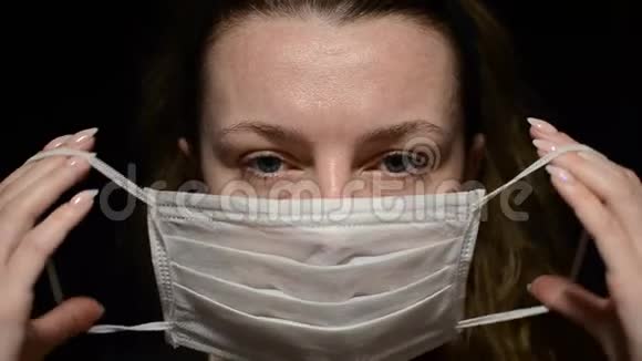 女人戴着黑色背景的医疗面具视频的预览图