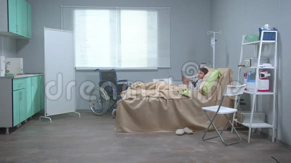 女孩躺在医院的床上手里拿着一块药片看着某处视频的预览图