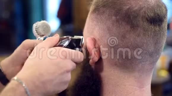 合拢剪发机在裁剪手做男性发型剪近耳朵的头发刷掉头发视频的预览图