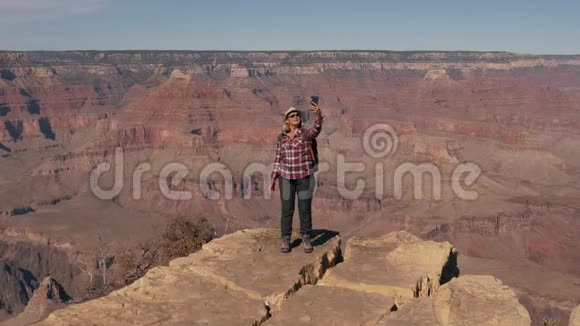 Hiker女士站在大峡谷悬崖边上的手机上自拍视频的预览图