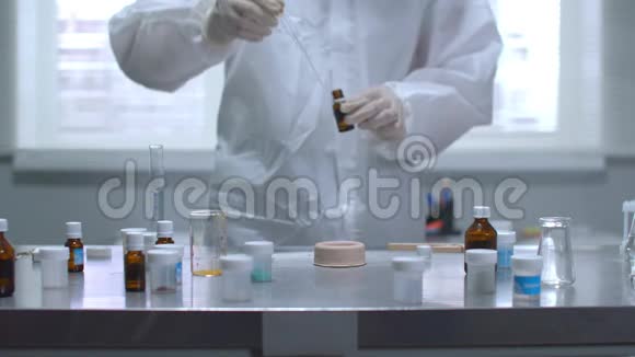 穿着防护服的人在实验室里放火烧桌子上的东西动作缓慢视频的预览图
