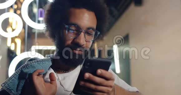 30多岁的严肃男人用智能手机聊天和打字戴眼镜的长胡子帅哥视频的预览图