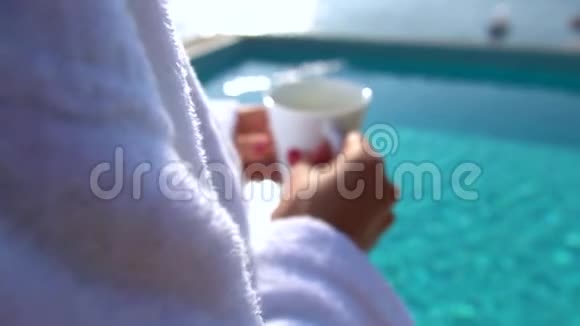早上在酒店游泳池喝咖啡的女人视频的预览图