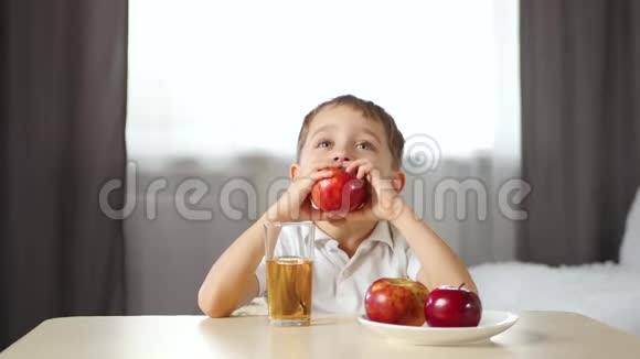 一个快乐的孩子咬掉一片红苹果竖起大拇指儿童健康食品的概念视频的预览图