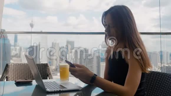 自信的商务女性在商务中心的露台上点击智能手机时尚美女在做视频的预览图