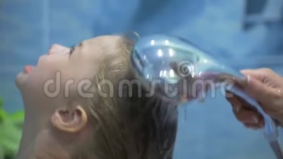 妈妈用婴儿洗发水给小女儿洗头照顾孩子视频的预览图