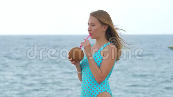 一位身穿蓝色泳衣的年轻女子站在靠近大海的码头上视频的预览图