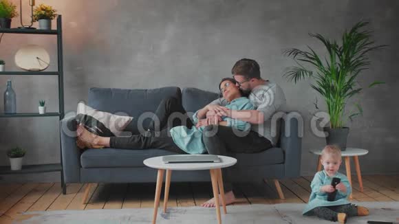 年轻的一家人一起在沙发上玩耍家庭幸福家庭舒适视频的预览图