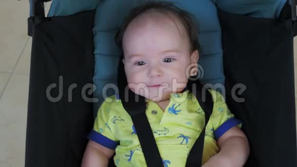 微笑的小男孩坐在婴儿车里笑视频的预览图