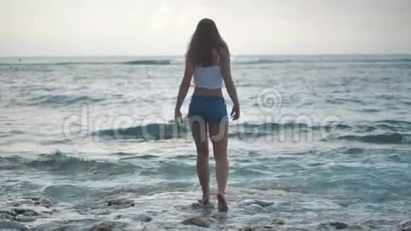 海洋上的一个女孩举起双手欣赏海浪4k视频的预览图