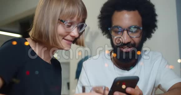 亲密的快乐朋友看着智能手机屏幕的照片笑了起来兴奋的男人和女人度过了美好的时光视频的预览图