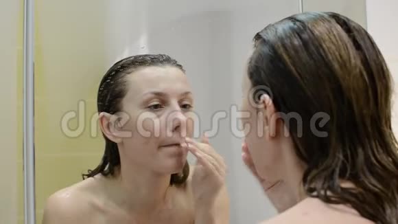 年轻迷人的女孩洗澡后照镜子视频的预览图