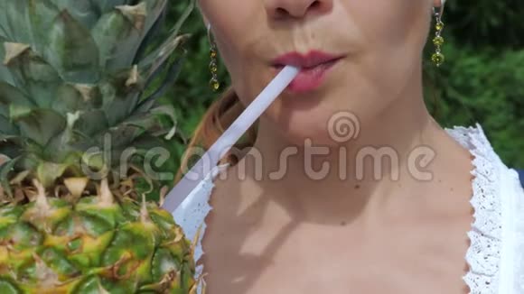 年轻女子用吸管喝菠萝鸡尾酒视频的预览图